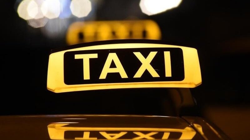Das Dachschild eines Taxis leuchtet bei Dunkelheit. (Symbolbild)