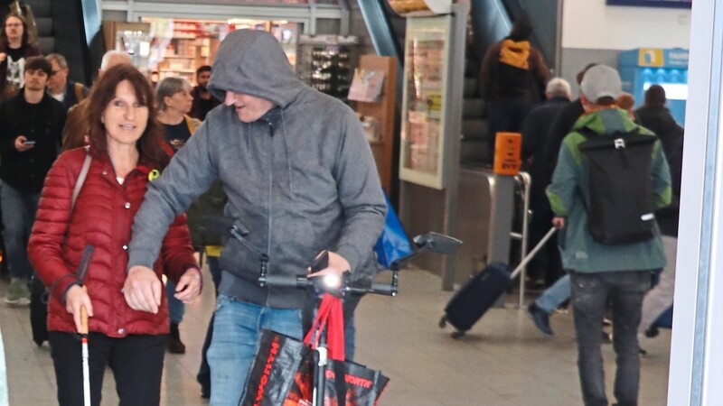 Beherzt nimmt der Mann mit E-Scooter und grauer Sweatshirt-Jacke Hannelore Winbeck an die Hand und führt sie zum Bahnhofsausgang.