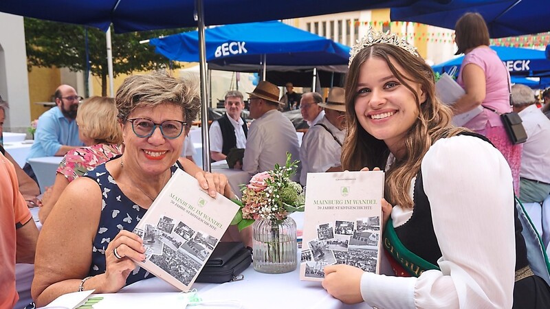 Vizebürgermeisterin Hannelore Langwieser und die Hallertauer Bierkönigin Karolin Ruhfaß blättern in der Stadtchronik.