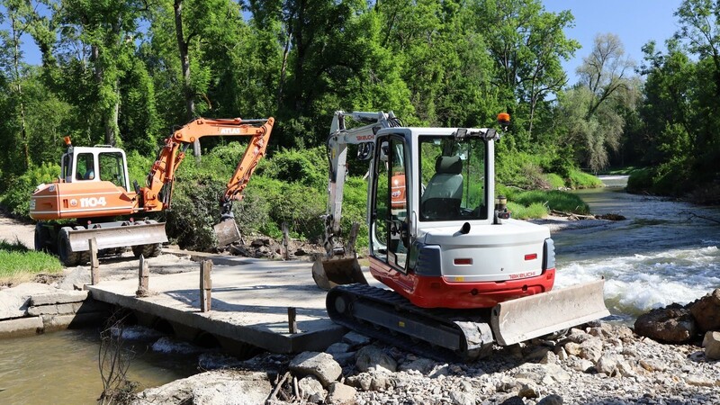 Derzeit machen Mitarbeiter des Moosburger Bauhofs die Brücke zumindest provisorisch passierbar - dabei stabilisieren sie die Ufer mit Steinblöcken und Flussbausteinen. Eine erneute Überspülung der Brücke kann diese Maßnahme allein aber nicht verhindern.