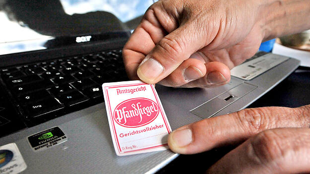 Ein Pfandsiegel wird von einem Gerichtsvollzieher auf einen Laptop geklebt. Eine Landshuterin hat jetzt für sie völlig überraschend Bekanntschaft mit einem behördlichen Vollzugsbeamten gemacht. Der hat ihr Konto gesperrt. Ein Pfandsiegel wird von einem Gerichtsvollzieher auf einen Laptop geklebt. Eine Landshuterin hat jetzt für sie völlig überraschend Bekanntschaft mit einem behördlichen Vollzugsbeamten gemacht. Der hat ihr Konto gesperrt.