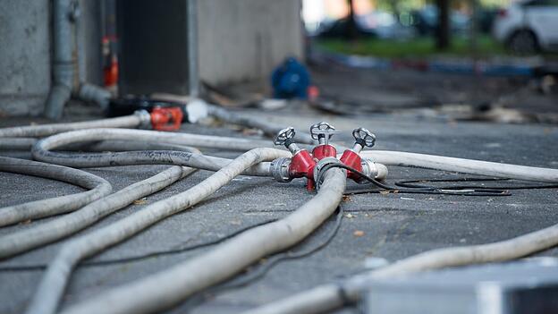 Feuerwehrleute löschten die brennenden Geräte draußen im Garten. Feuerwehrleute löschten die brennenden Geräte draußen im Garten.