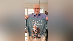 Hans-Josef Ersfeld (85) zeigt sein Motivationstrikot: 'Unterschätze niemals einen alten Mann', steht darauf. Hans-Josef Ersfeld (85) zeigt sein Motivationstrikot: 'Unterschätze niemals einen alten Mann', steht darauf.