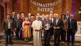 Feierstunde in der Allerheiligen-Hofkirche (erste Reihe v. l.): Pfarrer Pater Simeon Rupprecht mit der Urkunde und Bürgermeister Anton Piermeier mit dem Porzellan-Löwen, den ihnen Heimatminister Albert Füracker überreicht hat. Ebenfalls mit im Bild sind Landwirtschaftsministerin Michaela Kaniber (3. v. r.), Fürackers Staatssekretär Martin Schöffel (2. v. r.) sowie die Landtagsabgeordneten Josef Zellmeier (r., alle CSU) und Tobias Beck (hinten, Freie Wähler). Feierstunde in der Allerheiligen-Hofkirche (erste Reihe v. l.): Pfarrer Pater Simeon Rupprecht mit der Urkunde und Bürgermeister Anton Piermeier mit dem Porzellan-Löwen, den ihnen Heimatminister Albert Füracker überreicht hat. Ebenfalls mit im Bild sind Landwirtschaftsministerin Michaela Kaniber (3. v. r.), Fürackers Staatssekretär Martin Schöffel (2. v. r.) sowie die Landtagsabgeordneten Josef Zellmeier (r., alle CSU) und Tobias Beck (hinten, Freie Wähler).