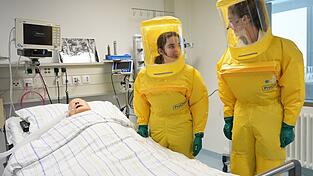 In Schutzanzügen arbeiten die Ärzte auf der Sonderisolierstation am Patienten - hier eine Puppe. In Schutzanzügen arbeiten die Ärzte auf der Sonderisolierstation am Patienten - hier eine Puppe.